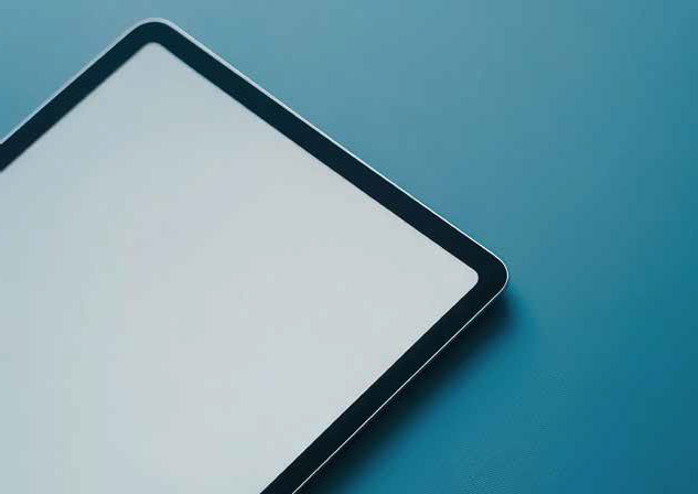 Ein Tablet liegt auf einem blauen Untergrund