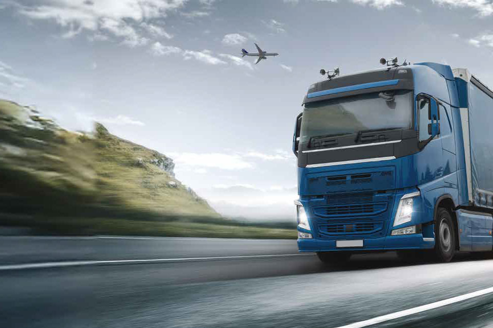 Ein blauer Lkw fährt entlang der Straße.